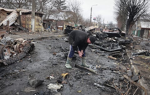 A local resident looks on the remains of a Russian military vehicle in Bucha, close to the capital Kyiv, Ukraine, Tuesday (Pic: PTI)