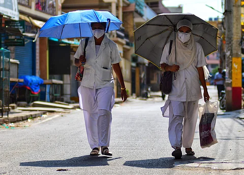 File picture of paramedical workers walk to wards to a COVID-19 red zone for collecting reports in Bengaluru | Express